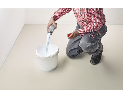 Une personne verse un liquide d''une bouteille dans un seau.