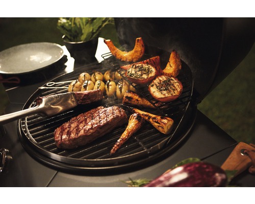 Légumes et viande sur un barbecue avec une pince à barbecue