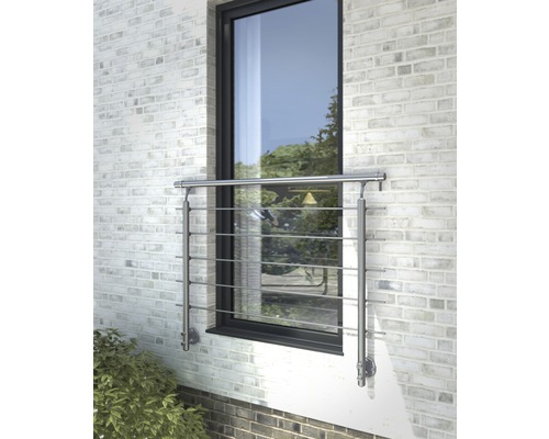 Fenster mit Edelstahl-Geländer vor einer Backsteinmauer