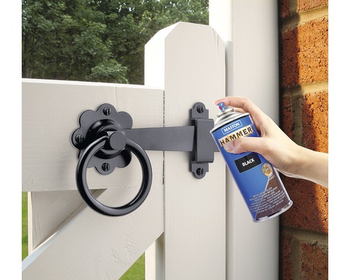 Sprühfarbe wird auf ein Gartentor aufgetragen