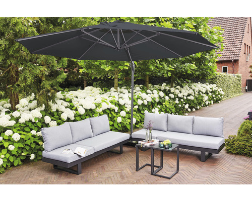 Gartenszene mit Sonnenschirm, Sofas und Tisch auf einer Terrasse