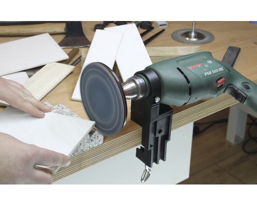 Perceuse avec meule et pièces sur une table