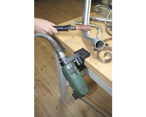 Scène d''atelier avec outil de ponçage pour le travail du métal et une perceuse fixée à un établi