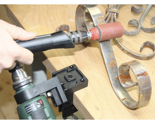 Personne ponçant du métal avec un outil de ponçage fixé à une perceuse