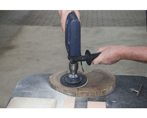 Schleifen eines Holzstücks mit einer Bohrmaschine und Schleifscheibe