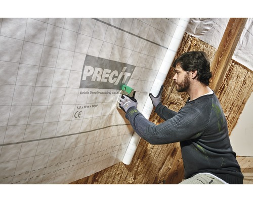 Un homme fixe un frein-vapeur de Precit avec une agrafeuse sur une structure de toit.