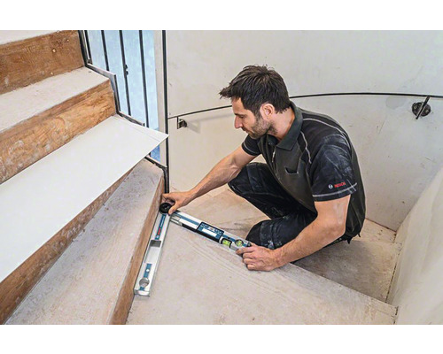 Artisan mesurant un escalier avec un rapporteur d'angle