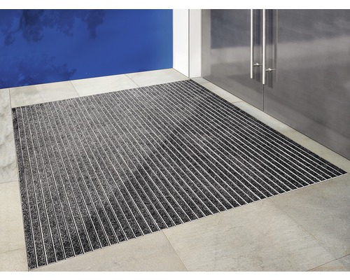 Paillasson avec profilés en aluminium devant une porte