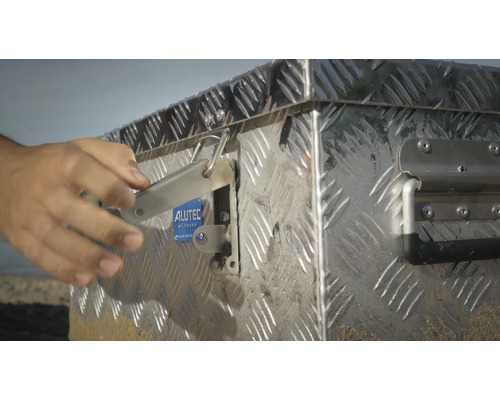 Aluminium Werkzeugkiste mit Hand beim Öffnen des Verschlusses