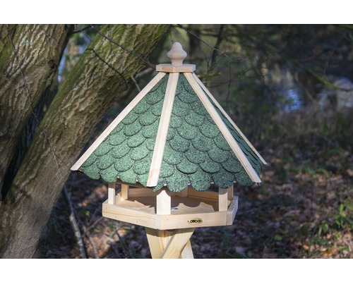 Maison pour oiseaux avec toit vert dans le jardin