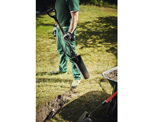 Mann mit Spaten, Graben und Schubkarre im Garten