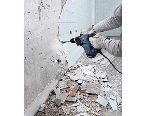 Une personne retire des carreaux avec un perforateur Bosch.