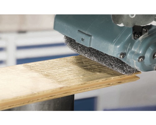 Ponceuse à brosse en cours d''utilisation sur une planche de bois