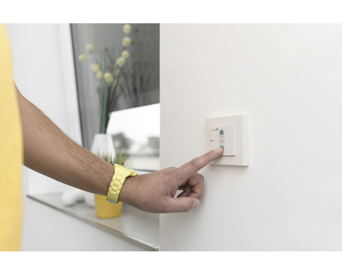 Personne actionnant un interrupteur sur le mur