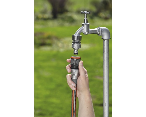 Gartenschlauch wird an einen Wasserhahn angeschlossen