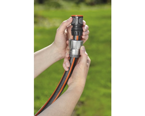 Zwei Hände verbinden einen Gartenschlauch mit einem Schlauchverbinder.