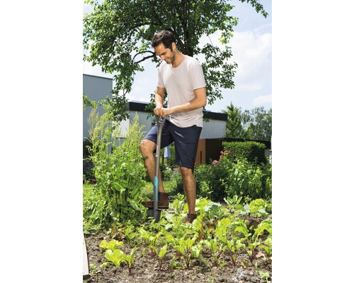 Un homme bêche le potager avec une bêche.
