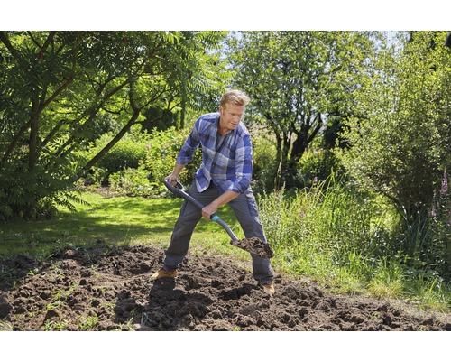 Homme bêchant dans le jardin avec une bêche.