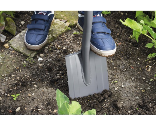 Personne enfonce une bêche dans la terre du jardin