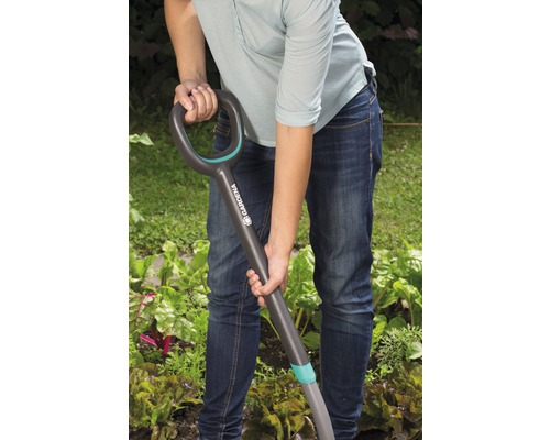 Une personne utilise une bêche dans le jardin.