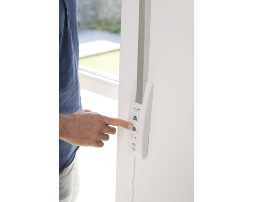 Une personne utilise un enrouleur de sangle électronique sur un mur