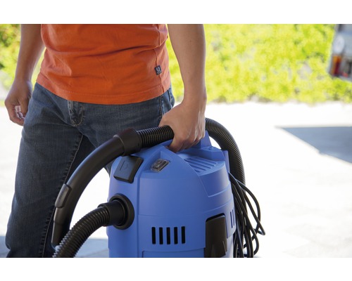 Personne tenant un aspirateur polyvalent bleu avec un tuyau noir.