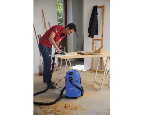 "Un homme ponce une planche de bois avec une ponceuse 