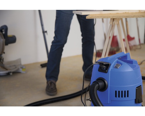 Scène d''atelier avec aspirateur, établi et artisan