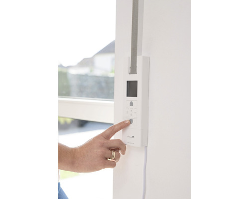 Une personne utilise la commande de volet roulant au mur