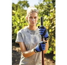 Femme portant des gants de jardinage bleus et noirs tenant un poteau