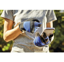 Une personne avec des gants de travail utilise un smartphone.