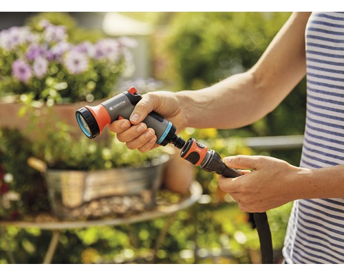 Gartenbrause wird an Gartenschlauch angeschlossen