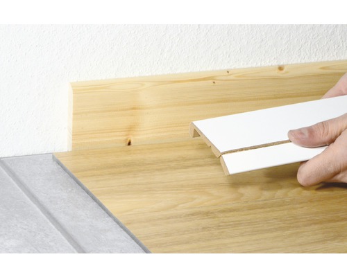 Sockelleiste wird an Holzwand angebracht