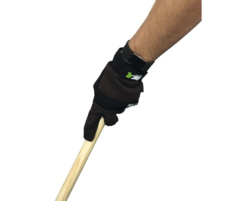 Une personne tient un manche en bois avec un gant de travail