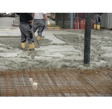 Betonarbeiten mit Bewehrungsgittern und Bauarbeitern.