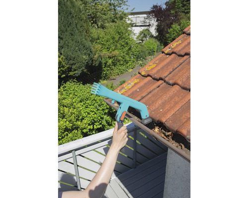 Personne nettoie une gouttière avec un nettoyeur de gouttière