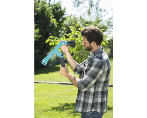 Un homme dans le jardin utilise un cueille-fruits pour la récolte.