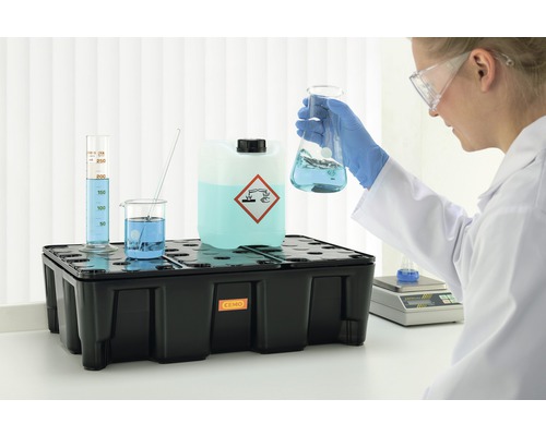 Bac de rétention avec symbole de danger et matériel de laboratoire dans un laboratoire