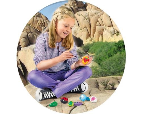 Fille peignant des pierres avec différents motifs à l''extérieur