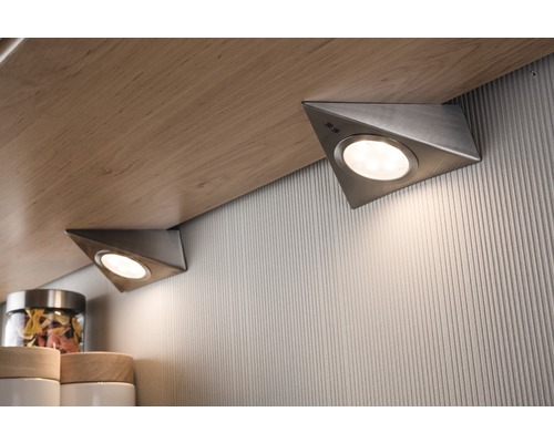 Zwei dreieckige Unterbauleuchten unter einem Holzregal.