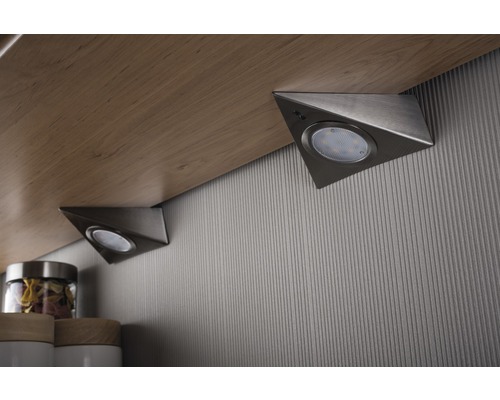 Zwei dreieckige Unterbauleuchten unter einem Regalbrett.