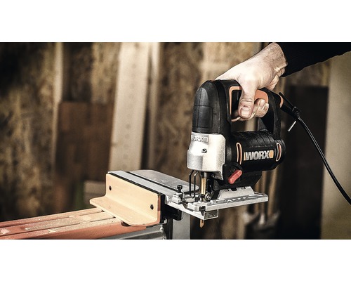 Hand hält Stichsäge beim Schneiden von Holz