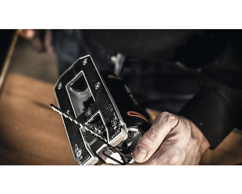 Nahaufnahme einer Stichsäge mit Sägeblatt in einer Hand