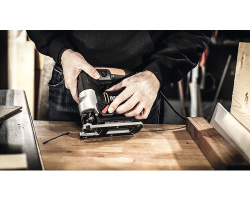 Eine Stichsäge im Einsatz auf einer Werkbank.