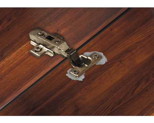 Charnière de meuble fixée sur du bois