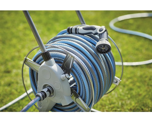 Aufroller mit Gartenschlauch und Spritzdüse im Garten