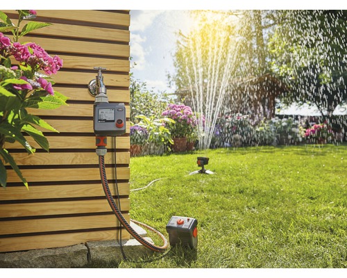 Gartenbewässerungssystem mit Bewässerungscomputer, Schlauch und Sprinkler im Garten