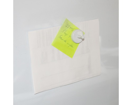 Papier mit Notiz befestigt mit einem Magneten