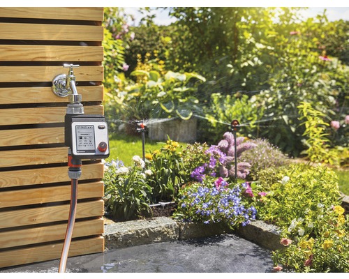 Gartenbewässerungssystem mit Bewässerungscomputer und Sprinklern in einem Garten