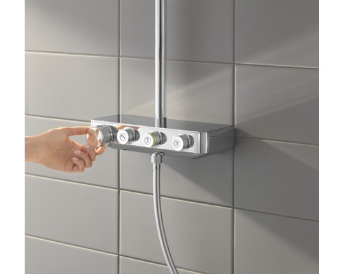Aufnahme einer Hand, die einen Thermostat an einer Duscharmatur mit Temperaturregler und Wassermengenregler bedient.
